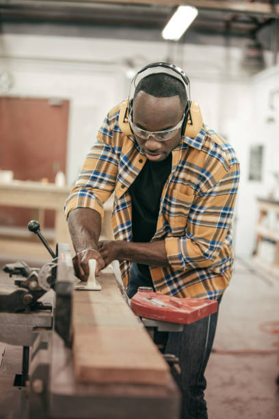 istock Male carpenter working with power tools in his wood shop 671065928