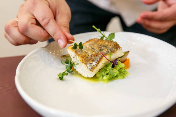 Cook cooks fish dish - baked fillet of pikeperch, zander