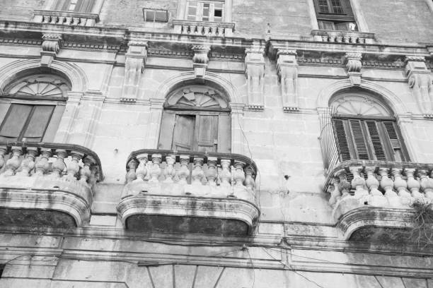 This is a black and white photograph of exterior balconies with arched windows, an architecture style common in Havana, Cuba. Photographed with a Nikon D800 DSLR camera.