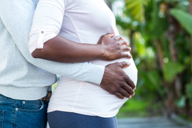 istock Man embracing his pregnant wife while standing 671072096
