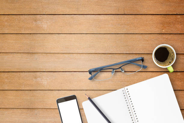 istock Notebook and smart phone on wooden table 671080994