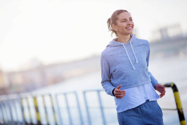 istock Young female running near the river 671098484