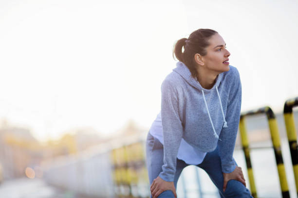 istock Young woman resting after running 671100654