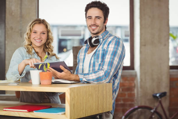 istock Happy business people holding digital tablet by table in office 671104816
