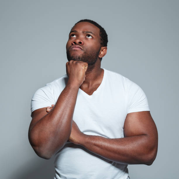 istock Muscular african man looking up and thinking 671107798