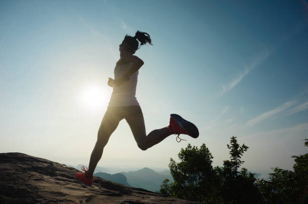 istock successful young woman running on sunrise mountain peak 671117868
