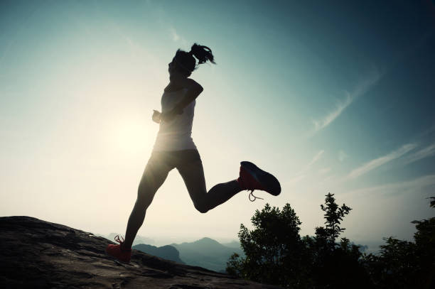 istock successful young woman running on sunrise mountain peak 671121342