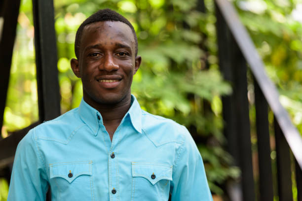 istock Young happy black African man smiling against modern staircase with nature 671124368