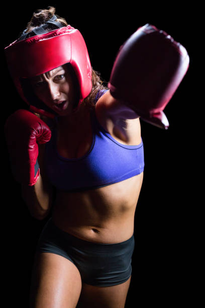 istock Female boxer with gloves and headgear punching 671149546