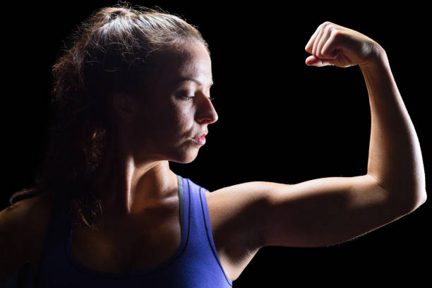 istock Confident female athlete flexing muscles 671149904