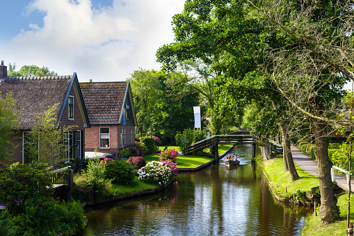 Overıjssel: Landscape view of famous houses with thatched roofs around canals. Giethoorn is very popular village.