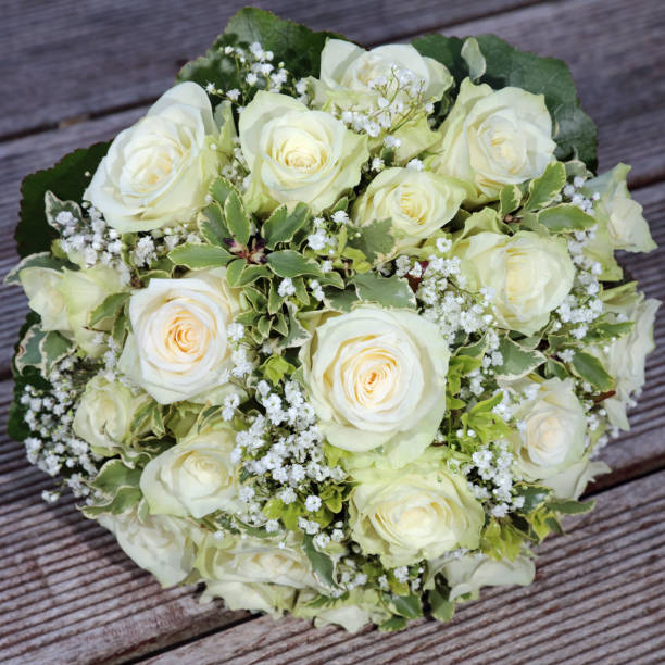 istock Bridal Bouquet with white Roses on wooden Plank 671156364