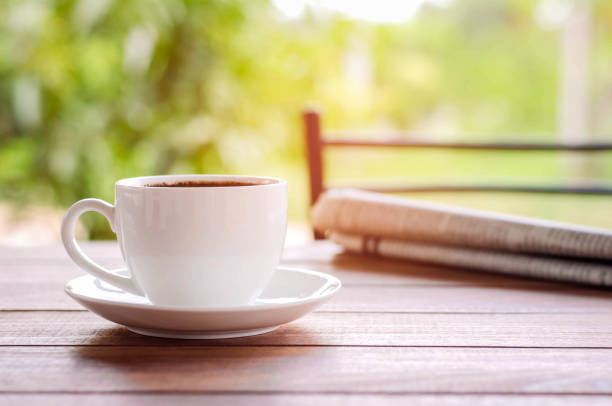 istock coffee cup with newspaper on the table at home  warm tone 671156384