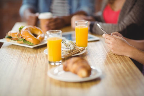 istock Cropped image of woman using phone during breakfast 671156766
