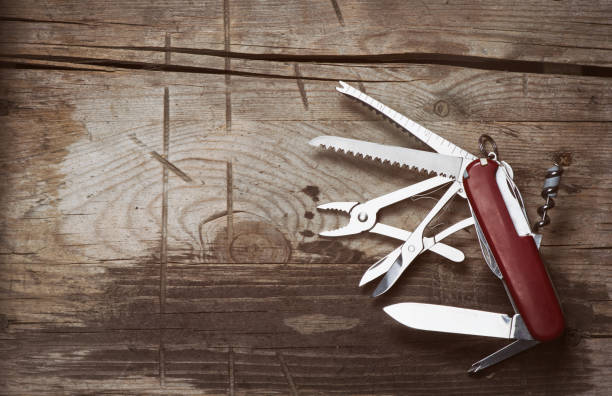 old Swiss knife on a wooden background old Swiss knife on a wooden background. Top view with copy space penknife stock pictures, royalty-free photos & images