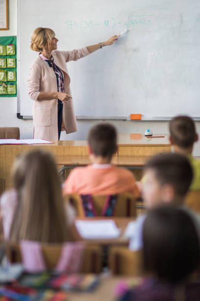 istock Smiling math teacher giving a lecture in the classroom. 671173846