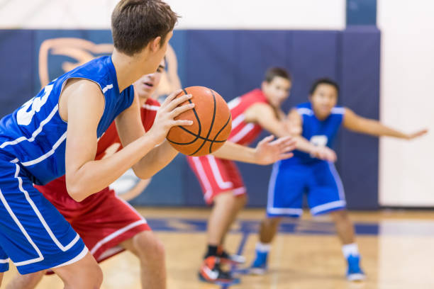 Boys high school basketball team: Boys high school basketball team: player about to shoot over defender youth basketball indoor stock pictures, royalty-free photos & images
