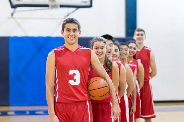 istock Mixed gender high school basketball team posing 671176560