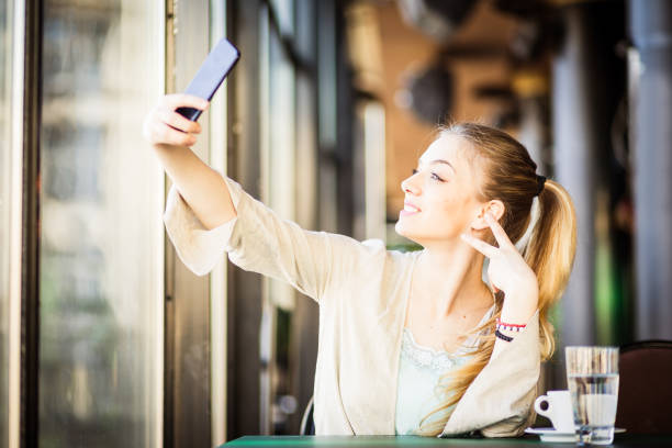 istock Woman drinking coffee texting, taking selfie 671179744
