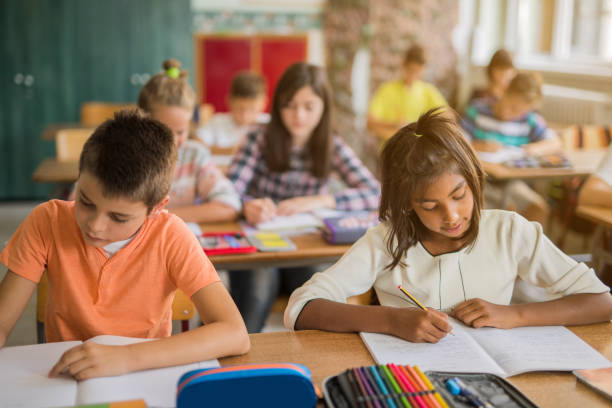 istock School kids writing during the lesson in the classroom. 671179862