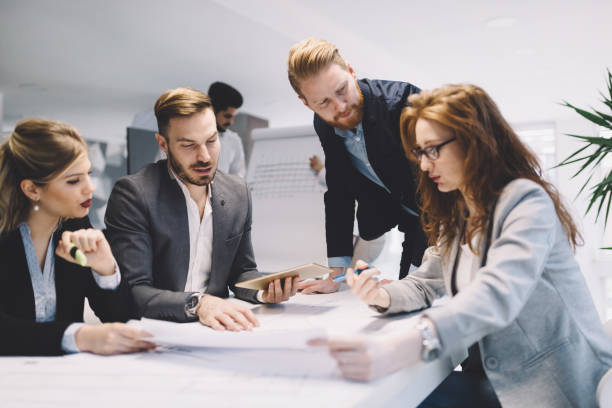 istock Business people and architects collaborating on business project 671182276