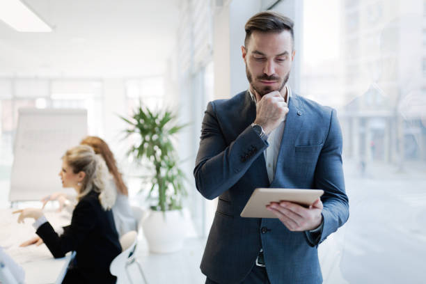 istock Businessman working and holding tablet in modern office 671182426