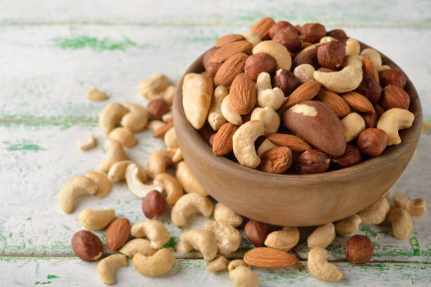 istock Mix of different nuts in a wooden bowl 671183064