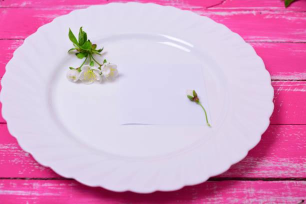 istock Empty white plate on a pink wooden surface, top view 671183954