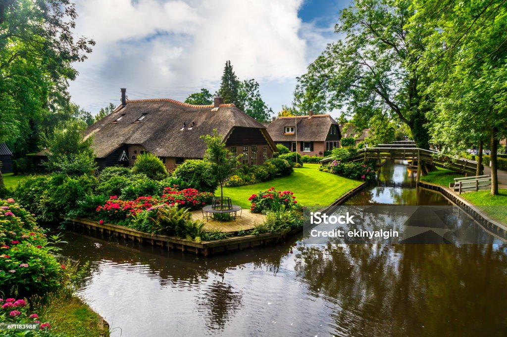 Giethoorn Village Scene Landscape view of famous Giethoorn village with canals and rustic thatched roof houses in farm area. Giethoorn Stock Photo