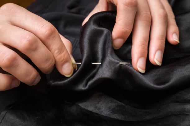 istock Hand with a needle and thread sewing clothes. Handmade. Womanly hobby. 671185578