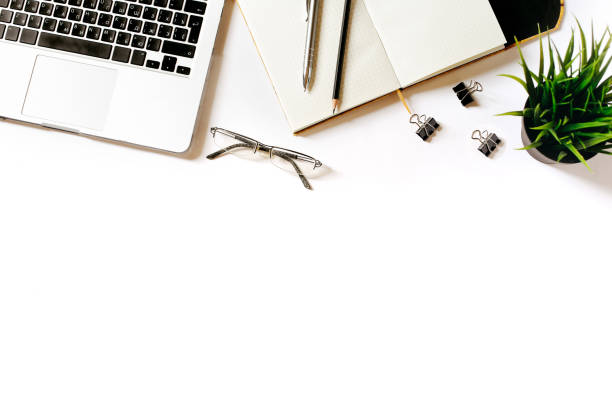 istock Modern minimalistic work place. White office desk table with laptop, clips, glasses, office plant, notebook, pen and pencil. Top view with copy space, flat lay 671186906