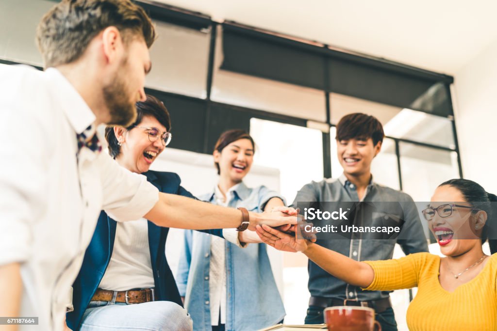 Groupe multiethnique diversifié de collègues heureux unissent leurs mains. Équipe créatrice, collègue d'affaires occasionnel, ou étudiants d'université dans la réunion de projet au bureau moderne. Concept de démarrage ou de travail d'équipe - Photo de Par équipe libre de droits