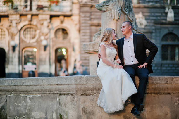 istock wedding couple siting on oldest monument on city Lviv 671190588