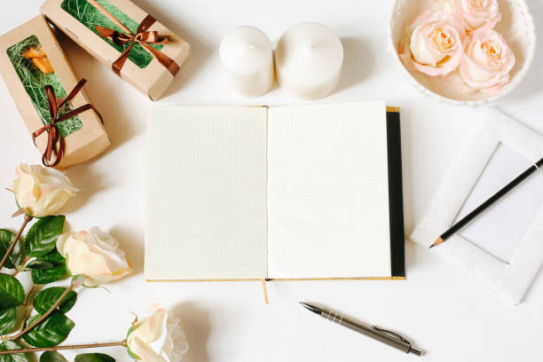 istock Opened empty diary, pen, vintage tray, candles, roses on white background. Flat Lay, top view, mockup 671192904