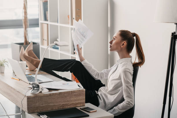 istock young concentrated businesswoman reading documents and sitting at table in office 671193524