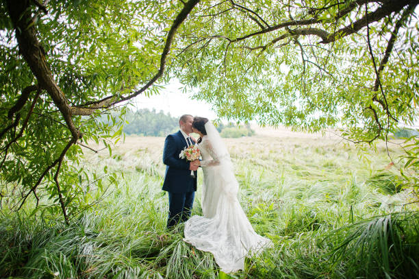 istock Wedding couple in high grass and near tree 671197372
