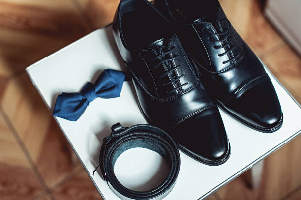 primo tempo di accessori moderni per l'uomo. papillon nero, scarpe di pelle e cintura. - shoe groom wood luxury foto e immagini stock