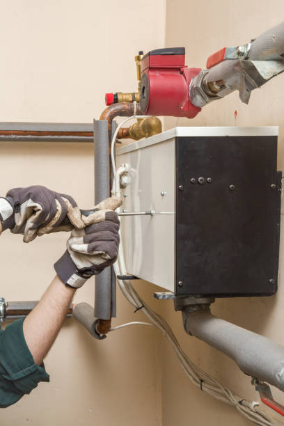 istock Man's hand in protective glove working with an adjustable wrench at water heater boiler equipment. Plumbing. 671200578