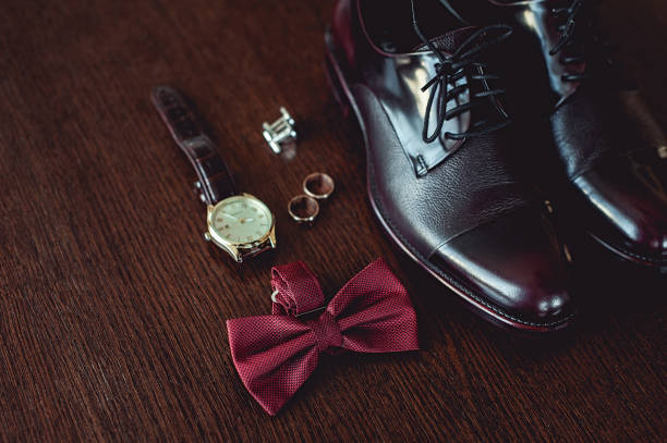 feche de acessórios do homem moderno. anéis de casamento, cereja bowtie, sapatos de couro, relógio e botões de punho - shoe groom wood luxury - fotografias e filmes do acervo