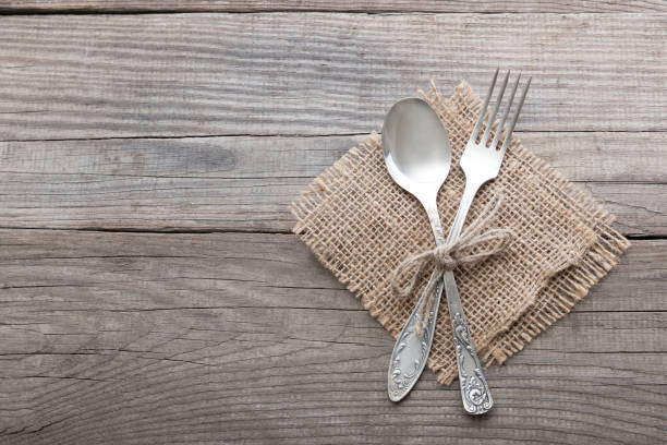 istock Old fork and spoon on a wooden table napkin and burlap, grunge rustic style, top view. 671200776