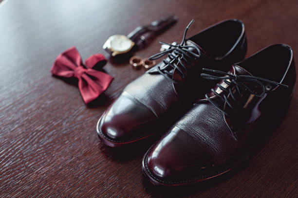 feche de acessórios do homem moderno. anéis de casamento, cereja bowtie, sapatos de couro, relógio e botões de punho - shoe groom wood luxury - fotografias e filmes do acervo