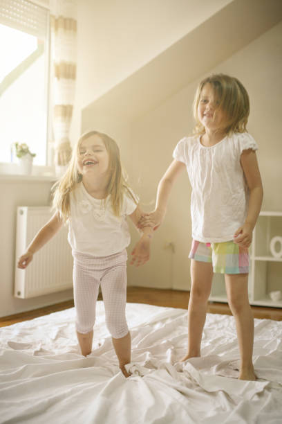 istock Two little girls playing together in bed. 671204398