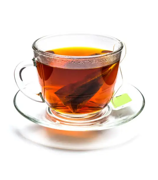 Transparent cup of black tea with tea bag isolated on white background