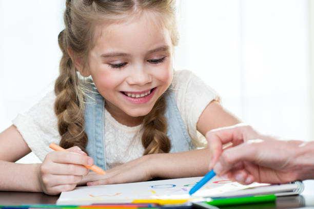 istock Happy mother and daughter drawing at home 671216914