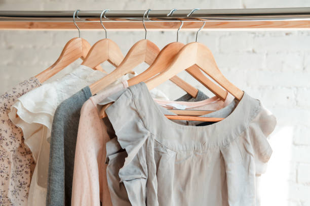 colgar ropa en el estante de la ropa - boutique fotografías e imágenes de stock