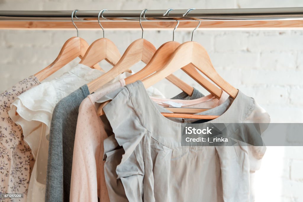 Clothes hang on clothing rack Female clothes on clothing rack. Pastel colors Clothing Stock Photo