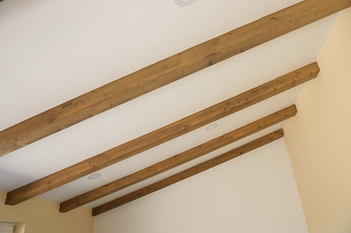 Modern wooden ceiling beams on white wall
