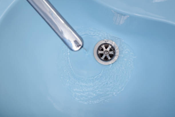 istock Water flows from the tap in a blue washbasin 671222298