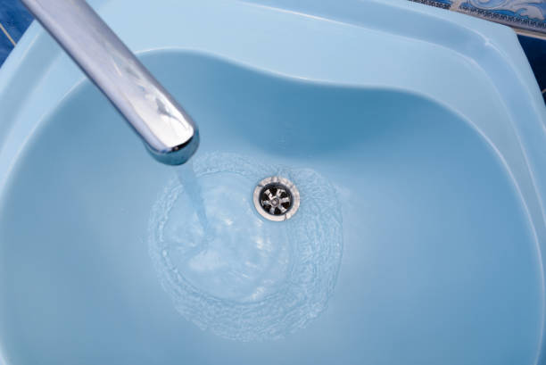 istock Water flows from the tap in a blue washbasin 671222584