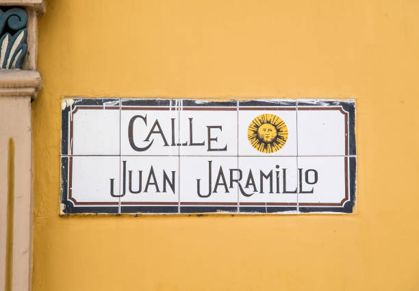 Old Fashion Tile Street name sign on yellow wall in the center part of the city of Cuenca in Peru, South America